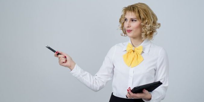 Das Foto zeigt eine Business Woman mit Stift und Tabloid in der Hand.